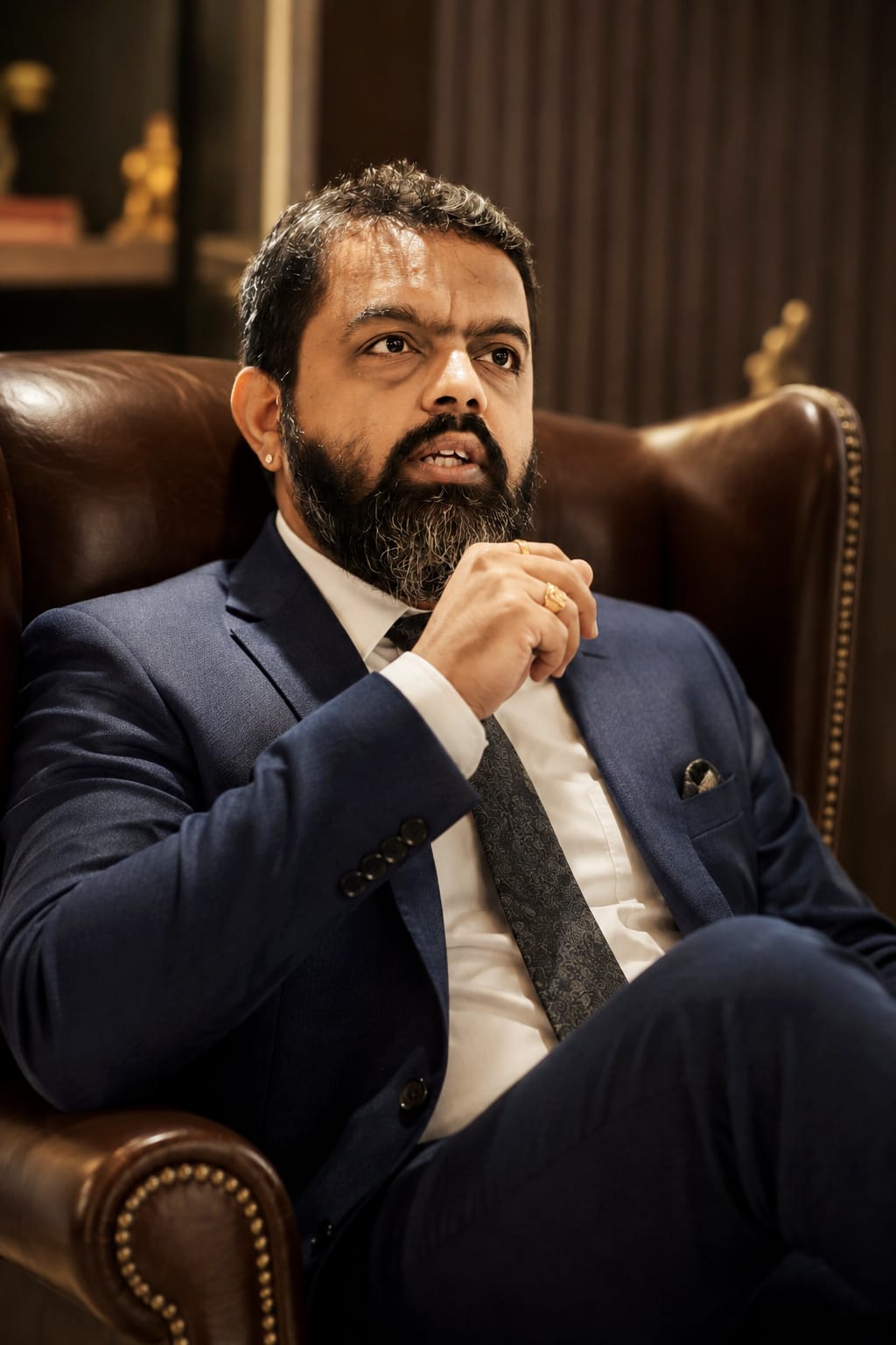Chaitanya Bailey seated in a leather armchair during an interview